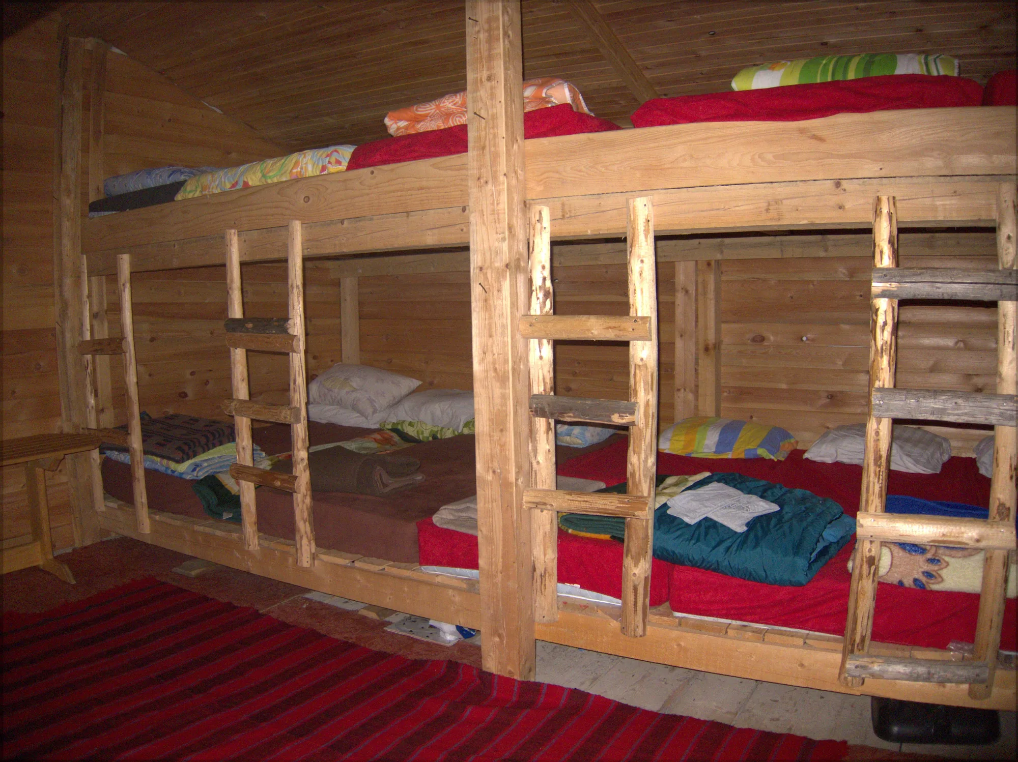 Bunks made up with blankets inside a timber mountain hut