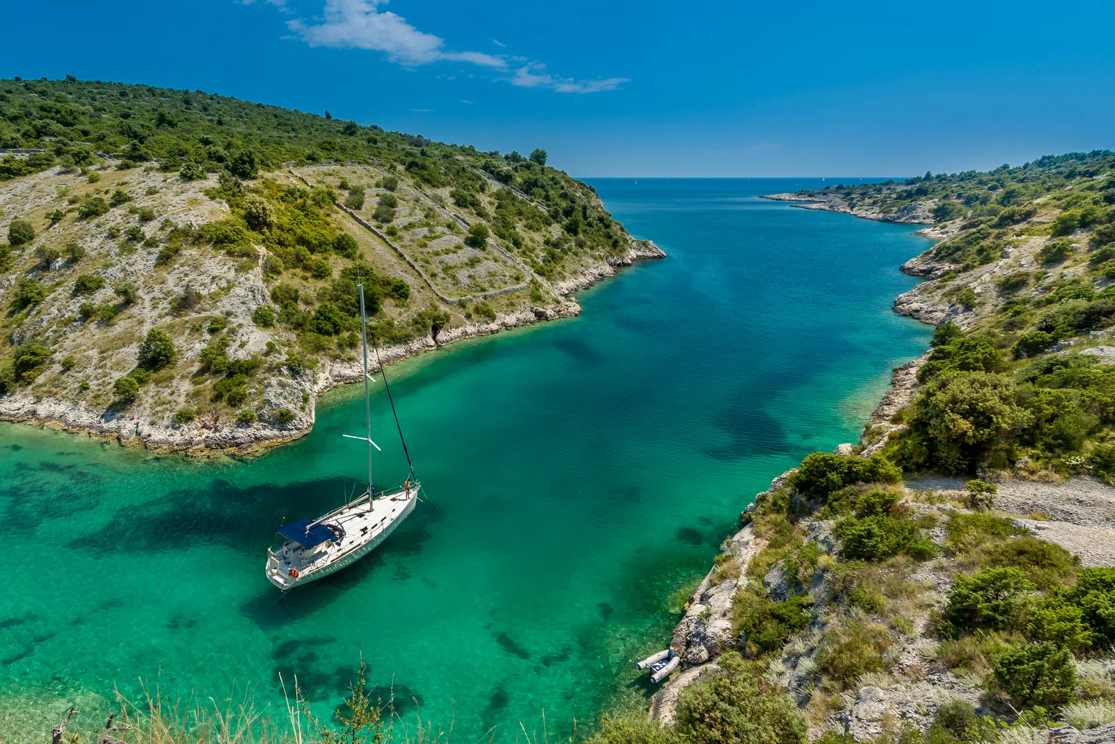 A small boat in a turquoise cove on the Albanian Riviera