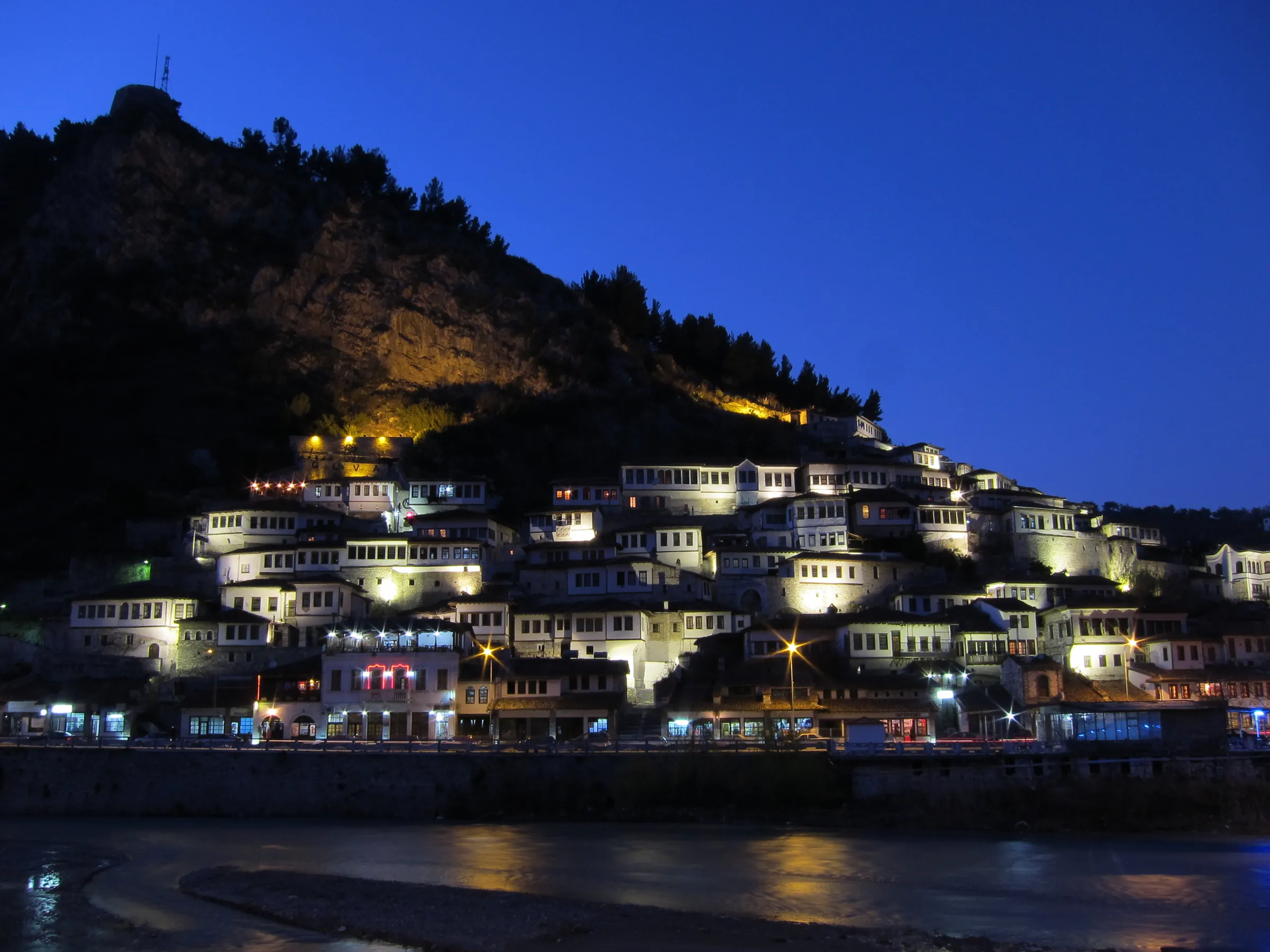 The Ottoman town of Berat lit at night above the river