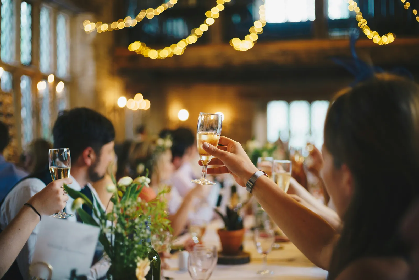 Guests raising glasses along a long dinner table
