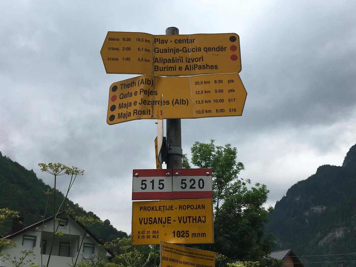 A trail signpost in the Albanian Alps showing walking times