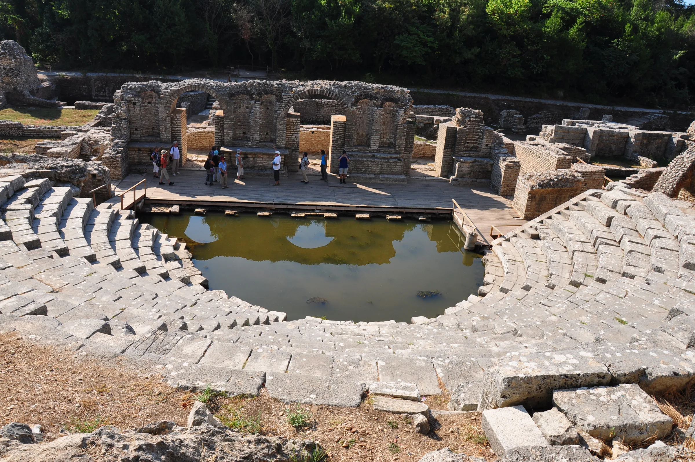 Visitors on the stage of the ancient theatre at Butrint